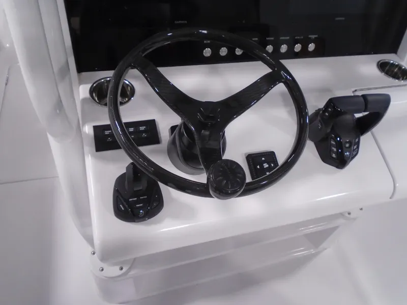 Slide: The Image of Steering console of 2025 Jupiter 32 boat with controls and black steering wheel. - 22