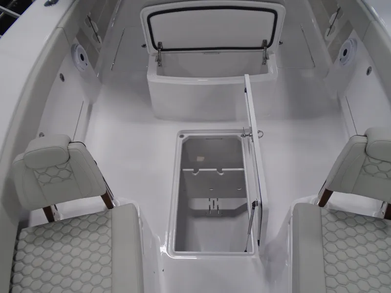 Slide: The Image of 2025 Jupiter 32 boat interior with open storage compartments and cushioned seating. - 29
