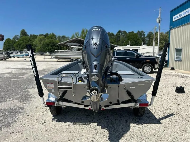 Slide: The Image of 2025 Xpress H210B boat with powerful outboard motor, parked outdoors. - 2
