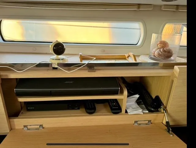 Slide: The Image of Interior of a 2016 Jeanneau 58 yacht with electronics and decor on a wooden shelf. - 18