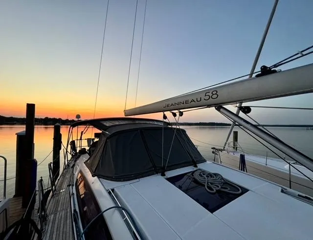 Slide: The Image of 2016 Jeanneau 58 yacht docked at sunset, showcasing sleek design and tranquil waters. - 24