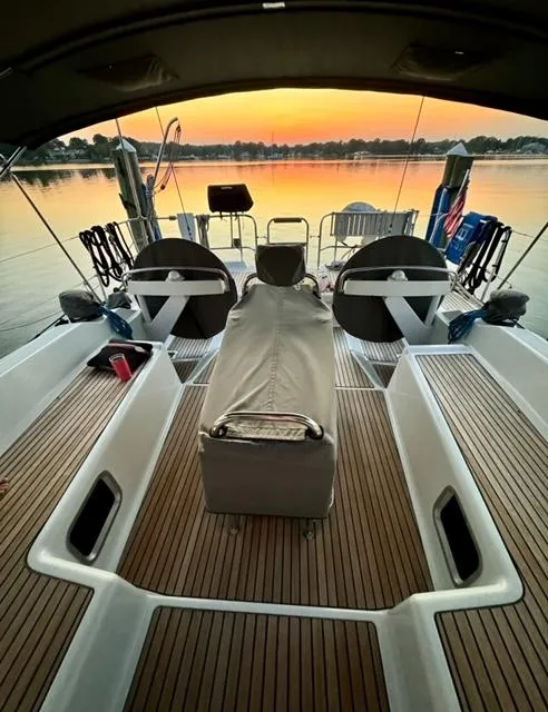 Slide: The Image of 2016 Jeanneau 58 yacht deck at sunset, featuring elegant seating and steering wheels. - 26