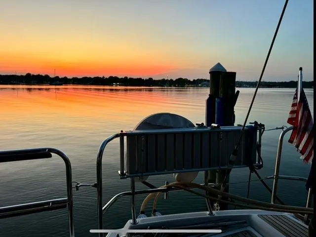 Slide: The Image of Jeanneau 58 sailboat at sunset, calm waters, American flag, 2016 model. - 27