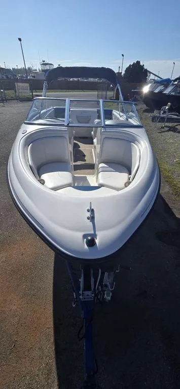 Slide: The Image of 2003 Reinell 185 boat with white interior and sleek design, parked outdoors. - 4