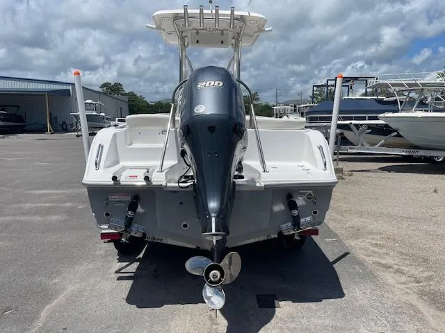 Slide: The Image of 2022 Sea Hunt Ultra 229 boat with outboard motor, parked on a sunny day. - 3