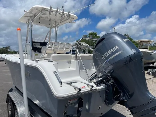Slide: The Image of 2022 Sea Hunt Ultra 229 boat with Yamaha engine, parked on a trailer under a cloudy sky. - 4