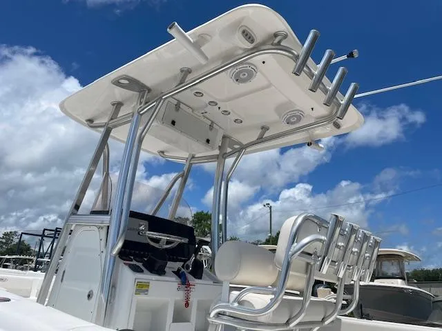 Slide: The Image of 2022 Sea Hunt Ultra 229 boat with T-top and seating, under a clear blue sky. - 5