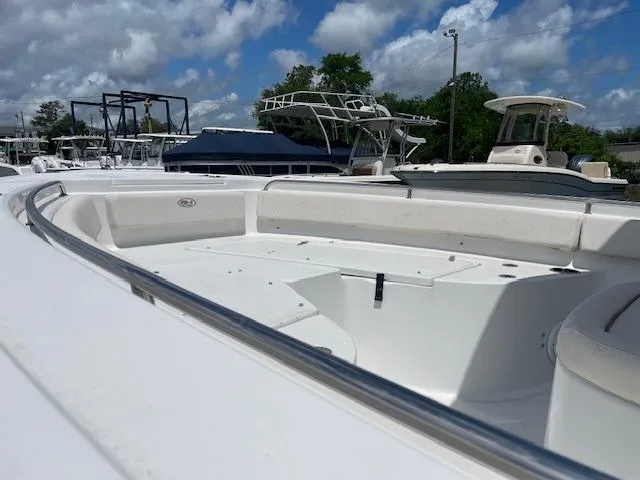 Slide: The Image of 2022 Sea Hunt Ultra 229 boat with spacious seating, docked under a partly cloudy sky. - 8