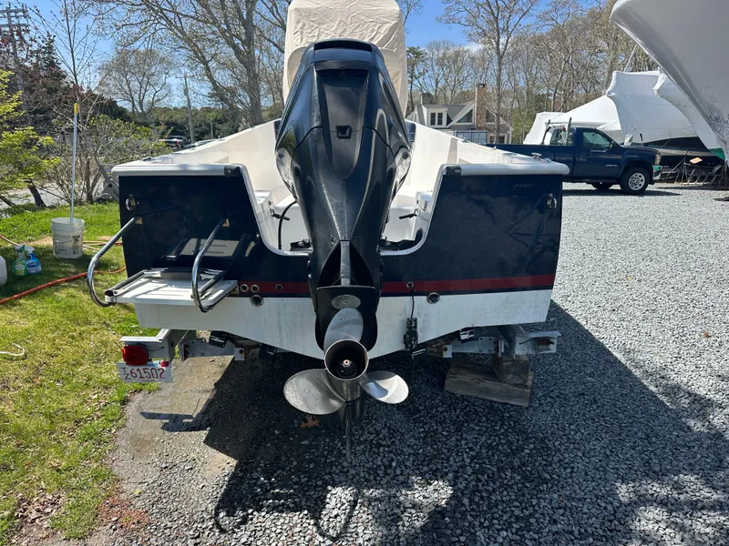 Slide: The Image of 2007 Holby Pilot 20 boat with outboard motor on gravel driveway. - 2