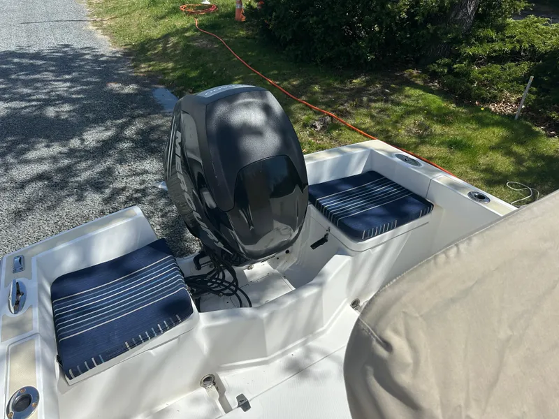 Slide: The Image of 2007 Holby Pilot 20 boat interior with striped seats and outboard motor. - 6