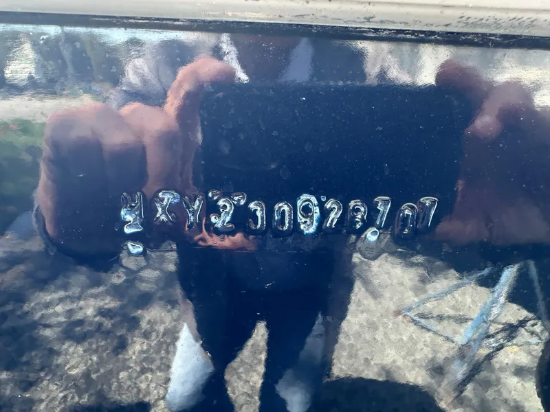 Slide: The Image of Close-up of a Holby Pilot 20 boat hull identification number, reflecting surroundings. - 9