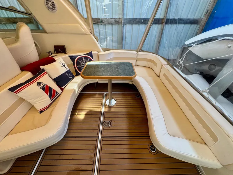 Slide: The Image of Luxurious seating area on 2000 Sea Ray 310 Sundancer with nautical-themed cushions and wooden flooring. - 11