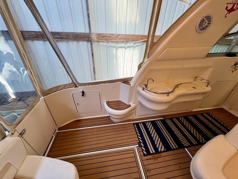 Slide: The Image of Interior of a 2000 Sea Ray 310 Sundancer boat with wood flooring and seating area. - 12