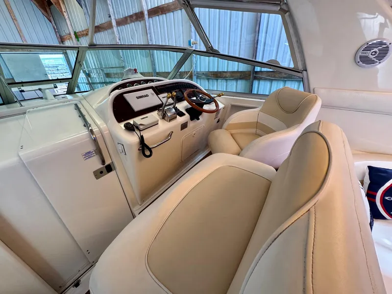 Slide: The Image of 2000 Sea Ray 310 Sundancer helm with beige seating and modern controls. - 15
