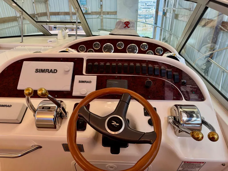 Slide: The Image of 2000 Sea Ray 310 Sundancer helm with Simrad electronics and wood-accented steering wheel. - 18