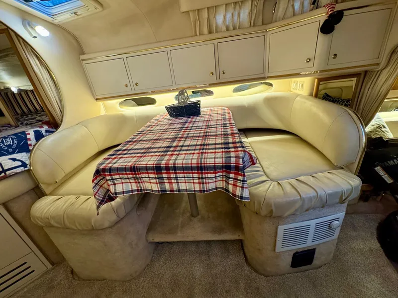 Slide: The Image of Interior of 2000 Sea Ray 310 Sundancer with cozy dining area and plaid tablecloth. - 23