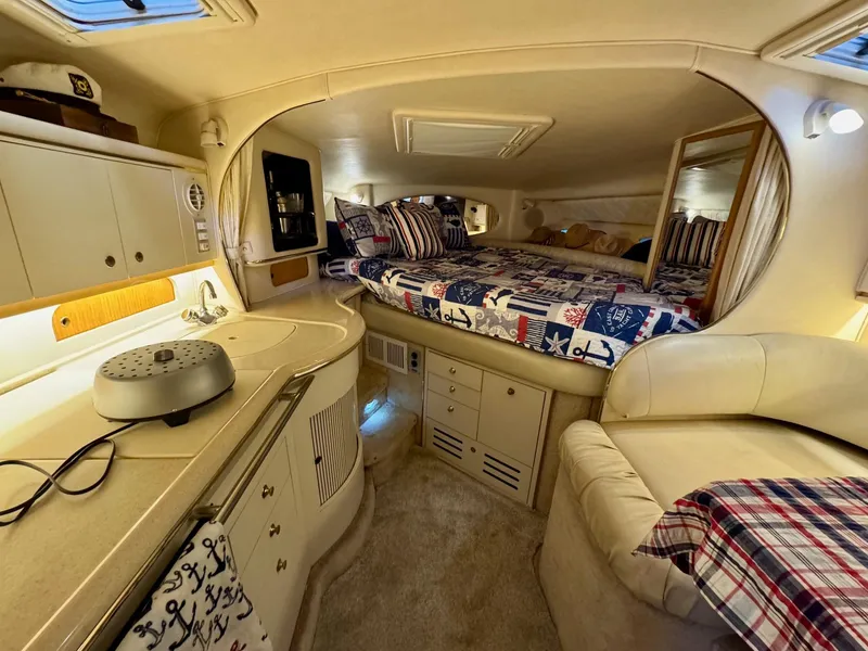 Slide: The Image of 2000 Sea Ray 310 Sundancer cabin interior with cozy bed and kitchenette. - 24