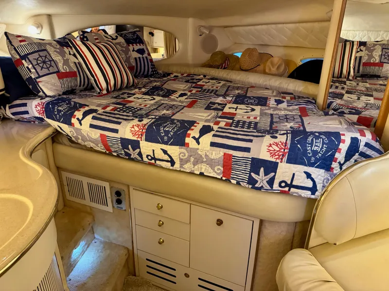 Slide: The Image of Interior cabin of 2000 Sea Ray 310 Sundancer with nautical-themed bedding and cozy sleeping area. - 25