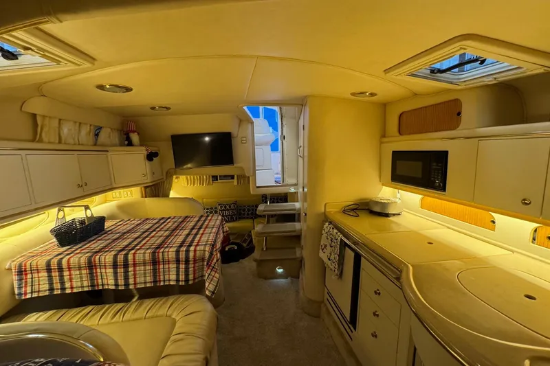 Slide: The Image of Interior of 2000 Sea Ray 310 Sundancer yacht with cozy dining and kitchen area. - 29