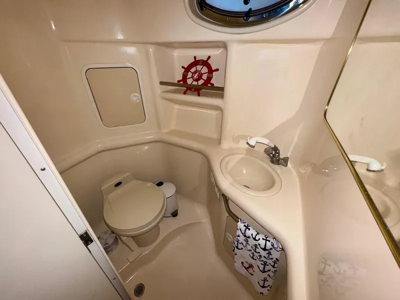 Slide: The Image of Bathroom interior of 2000 Sea Ray 310 Sundancer boat, featuring toilet and sink. - 34