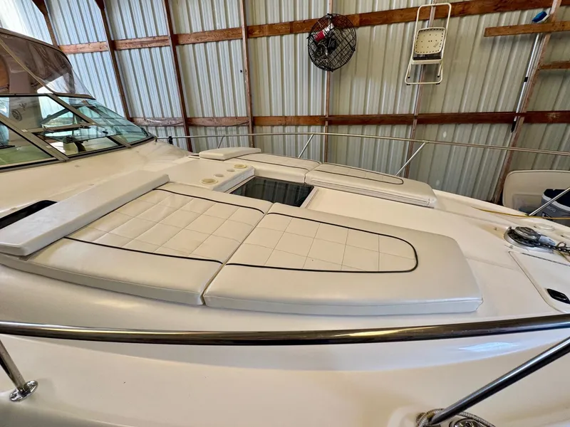 Slide: The Image of 2000 Sea Ray 310 Sundancer boat with cushioned deck, stored indoors. - 4
