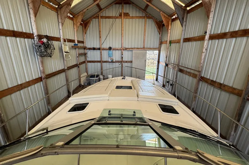 Slide: The Image of 2000 Sea Ray 310 Sundancer stored in a metal boathouse, viewed from the bow. - 42