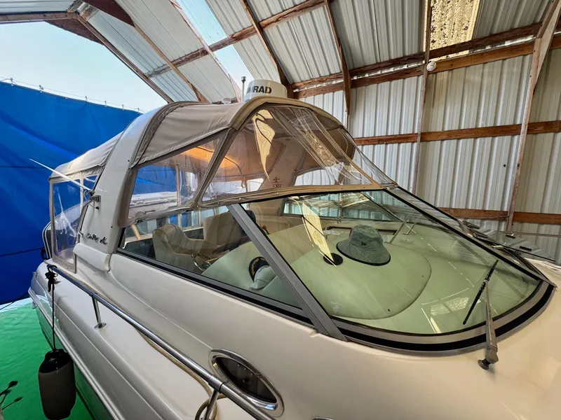 Slide: The Image of 2000 Sea Ray 310 Sundancer boat in covered storage, featuring a sleek design and canopy. - 5