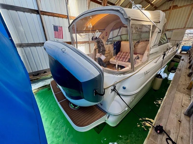 Slide: The Image of 2000 Sea Ray 310 Sundancer docked in a covered marina with American flag. - 6
