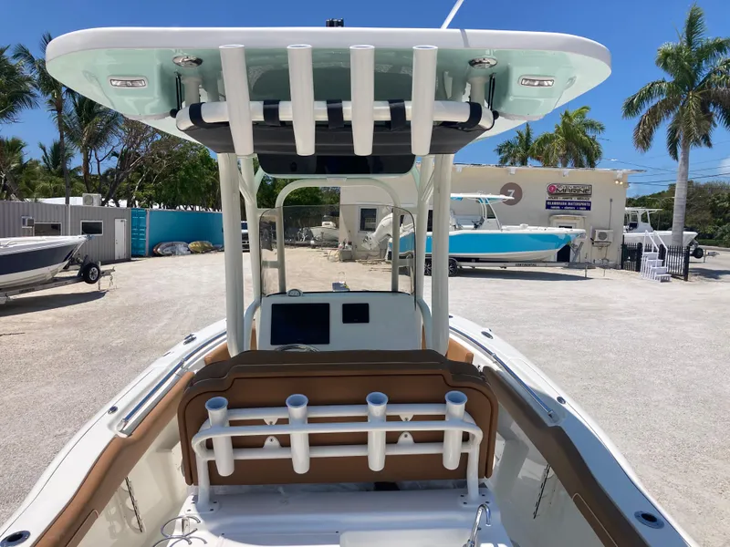 Slide: The Image of 2025 Key West 239FS boat with T-top and rod holders in a sunny marina. - 6