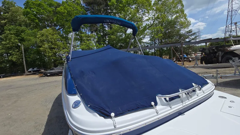 Slide: The Image of 2006 Crownline 262 EX boat with blue cover, parked outdoors. - 10