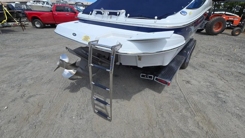 Slide: The Image of 2006 Crownline 262 EX boat with ladder and propeller, parked on gravel. - 14