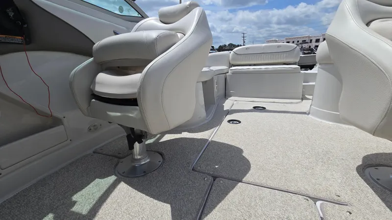 Slide: The Image of 2006 Crownline 262 EX boat interior with plush seating and spacious deck under a blue sky. - 25