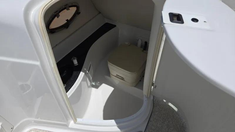 Slide: The Image of 2006 Crownline 262 EX boat interior with compact bathroom and portable toilet. - 40
