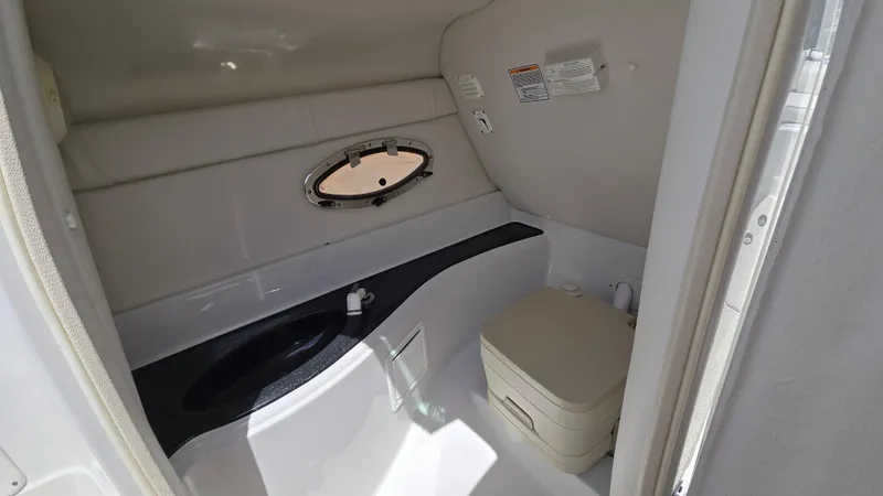 Slide: The Image of 2006 Crownline 262 EX boat interior bathroom with porthole and compact toilet. - 41