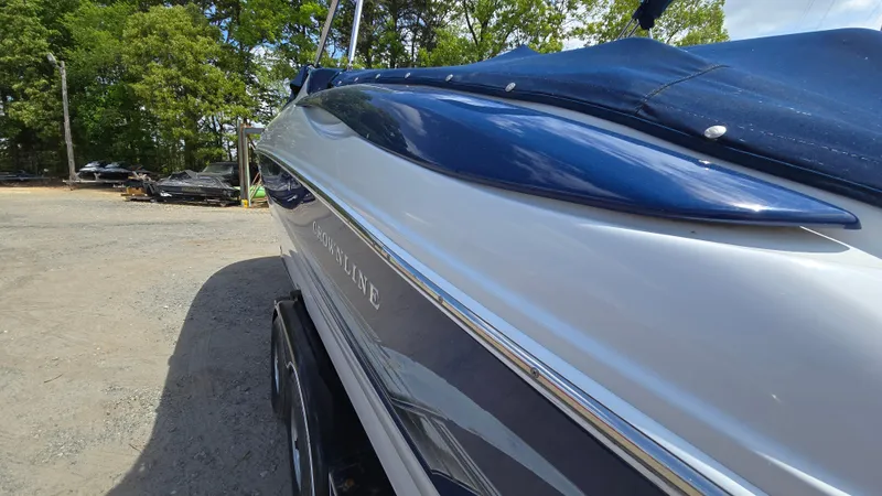 Slide: The Image of 2006 Crownline 262 EX boat with blue cover, parked outdoors. - 8
