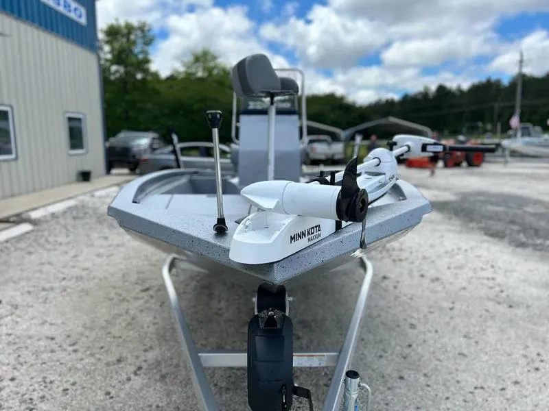 Slide: The Image of 2025 Xpress H190B boat with Minn Kota motor on gravel lot, under cloudy sky. - 3