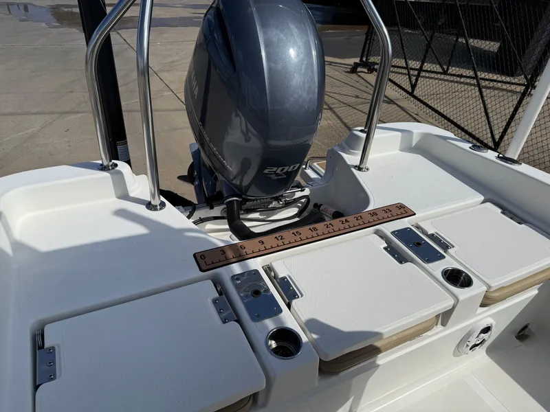 Slide: The Image of 2019 NauticStar 231 Hybrid boat with outboard motor and deck storage compartments. - 18