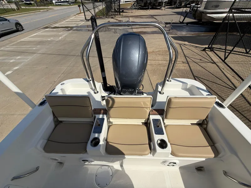 Slide: The Image of 2019 NauticStar 231 Hybrid boat with beige seating and outboard motor, docked at marina. - 19