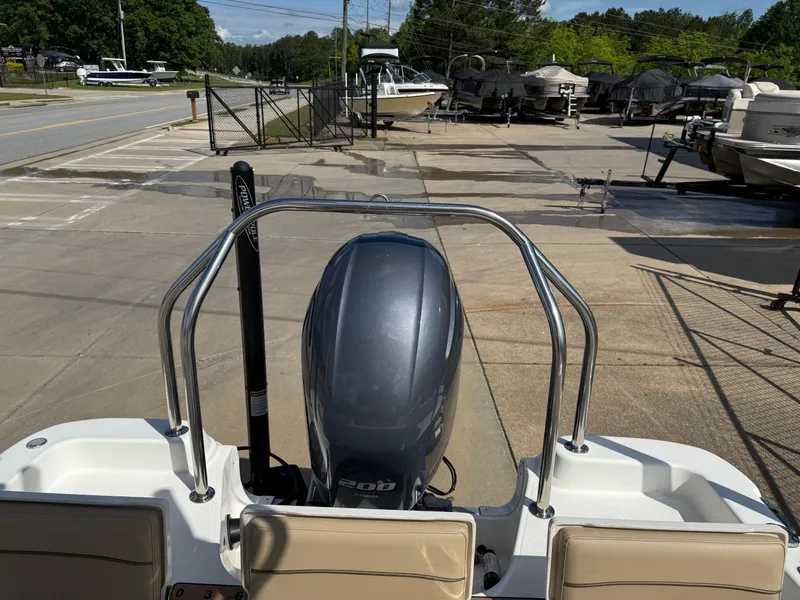 Slide: The Image of 2019 NauticStar 231 Hybrid boat with outboard motor, parked at a marina. - 20