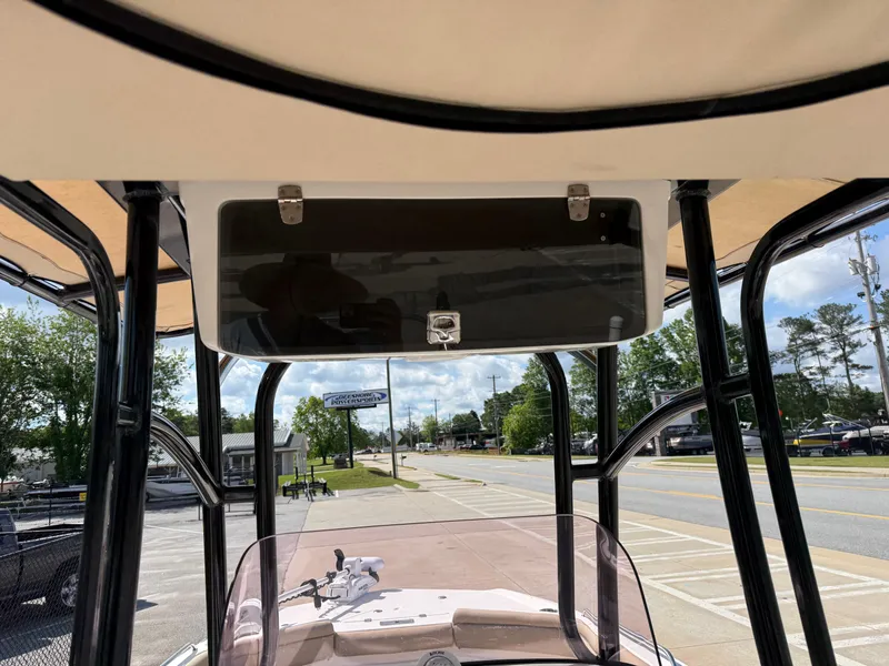 Slide: The Image of 2019 NauticStar 231 Hybrid boat console with storage compartment, parked on a sunny day. - 22