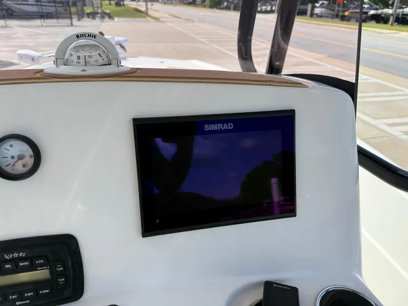 Slide: The Image of 2019 NauticStar 231 Hybrid boat dashboard with Simrad display and compass. - 24
