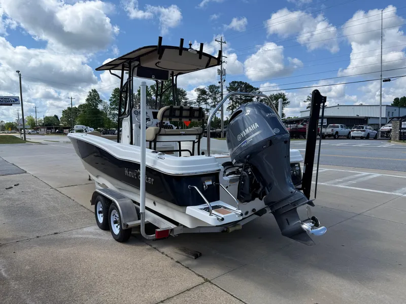 Slide: The Image of 2019 NauticStar 231 Hybrid boat on trailer, featuring Yamaha outboard motor, parked outdoors. - 3