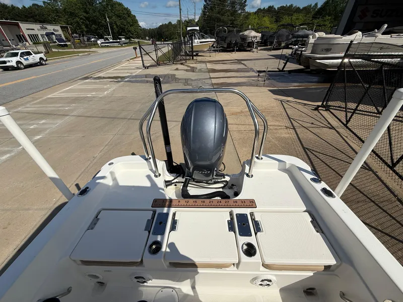 Slide: The Image of 2019 NauticStar 231 Hybrid boat with outboard motor, parked on a concrete lot. - 33