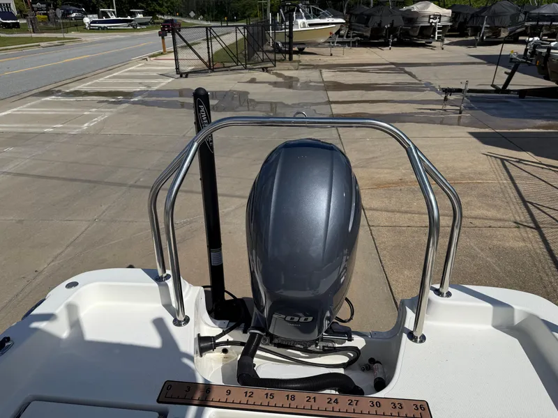 Slide: The Image of 2019 NauticStar 231 Hybrid boat with outboard motor at a marina. - 34