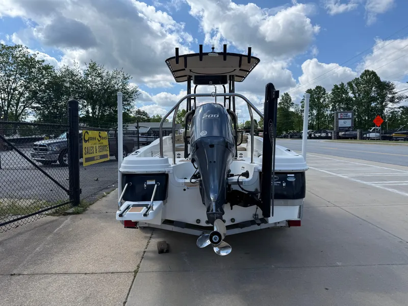 Slide: The Image of 2019 NauticStar 231 Hybrid boat with Yamaha outboard motor, parked on pavement under cloudy sky. - 4