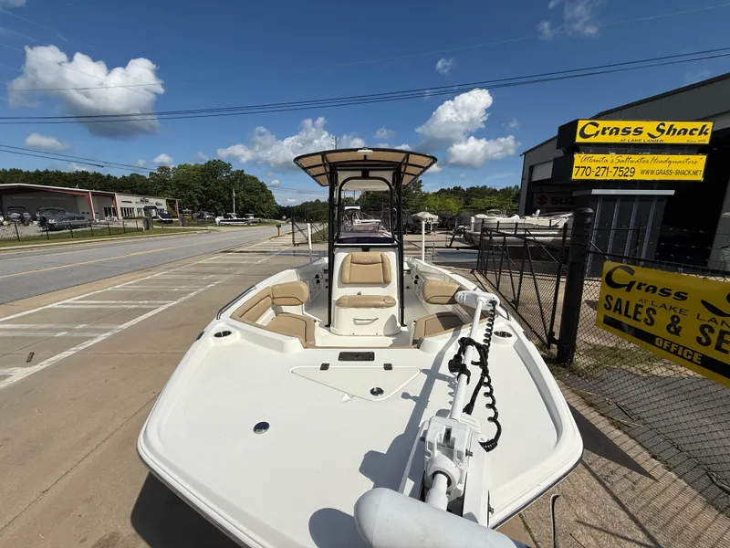 Slide: The Image of 2019 NauticStar 231 Hybrid boat displayed at dealership under clear blue sky. - 6