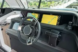 Slide: The Image of 2024 Axopar 45 helm with dual navigation screens and modern steering wheel. - 6