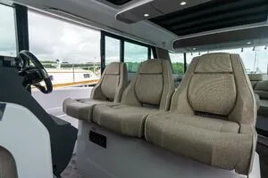 Slide: The Image of 2024 Axopar 45 XC Cross Cabin interior with plush seating and table, docked at marina. - 9