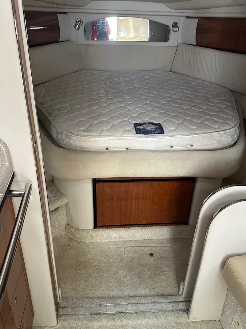 Slide: The Image of 2004 Sea Ray 360 Sundancer cabin with bed, wooden accents, and cozy interior. - 14