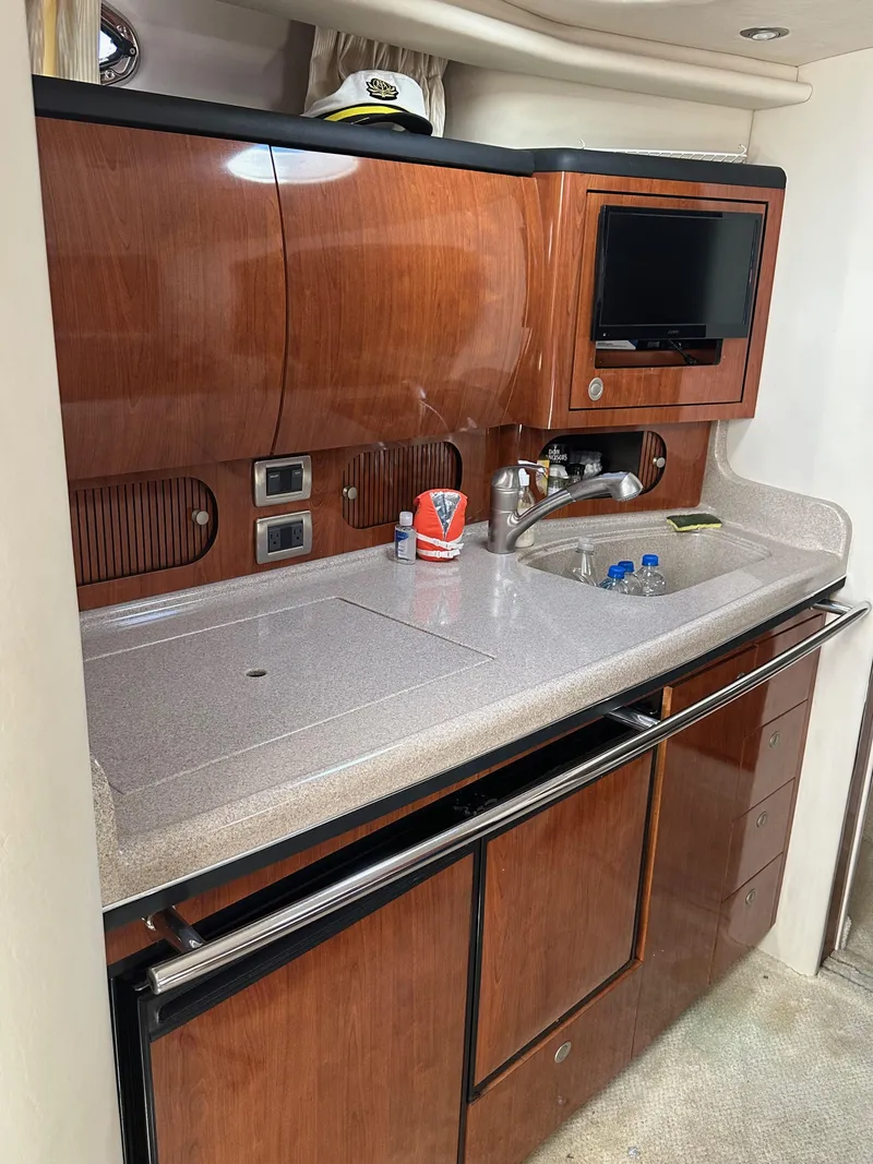 Slide: The Image of 2004 Sea Ray 360 Sundancer yacht kitchen with wood cabinetry and modern amenities. - 17